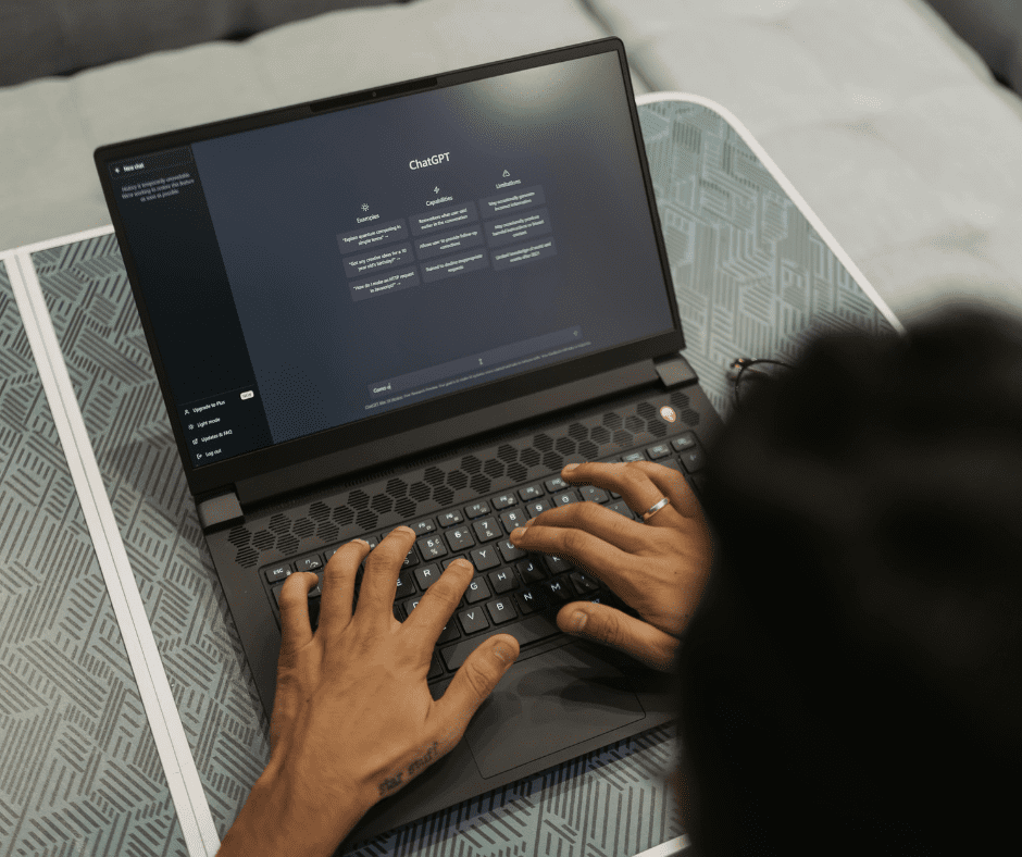 Man sitting at a desk using ChatGPT on a laptop to plan his upcoming trip, with travel notes and a coffee cup nearby.